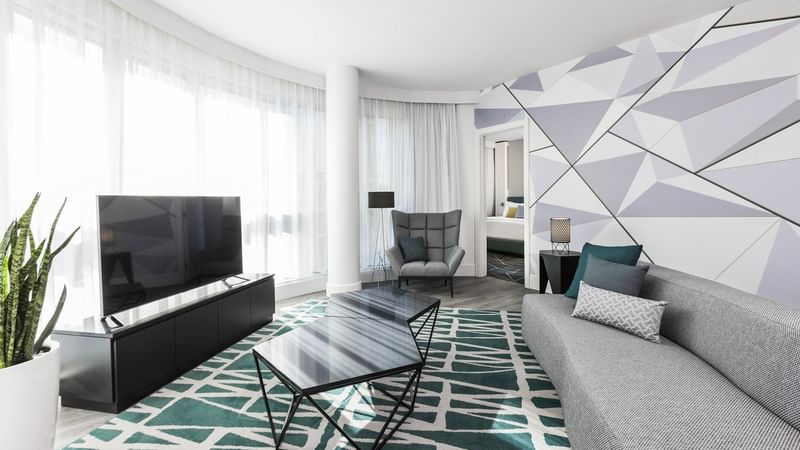 Living space with a sofa, TV and comfy armchair in Crystal Suite at Warwick Le Crystal