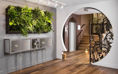 lobby with staircase and foliage decorations on wall