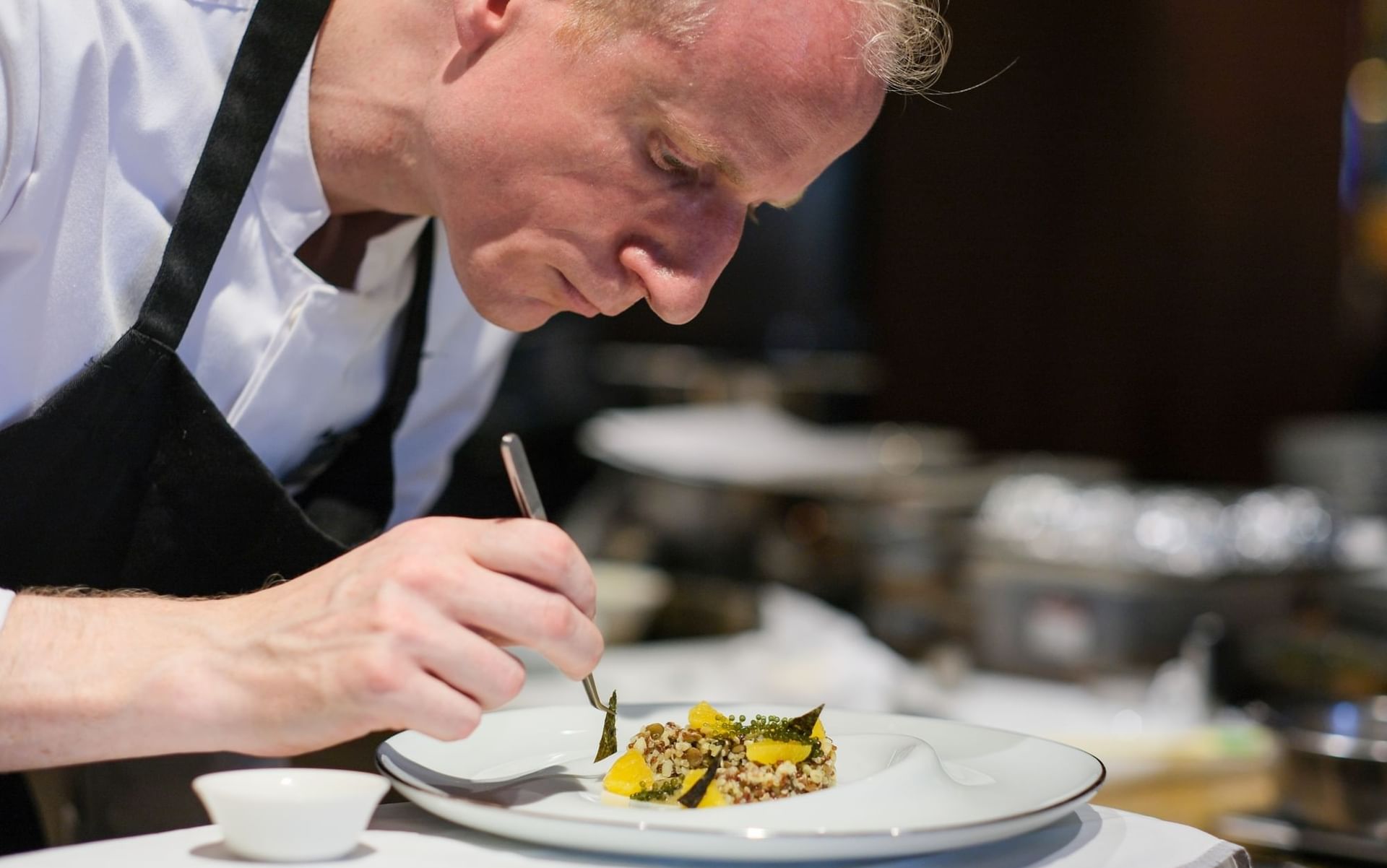 Close-up of chef paying close attention in garnishing a dish served in Square One at Park Hyatt Saigon