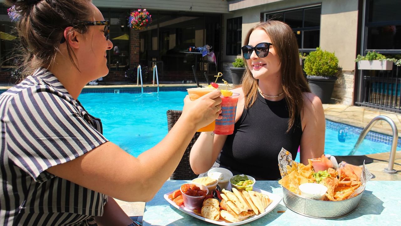 Two guests eating a meal by the pool