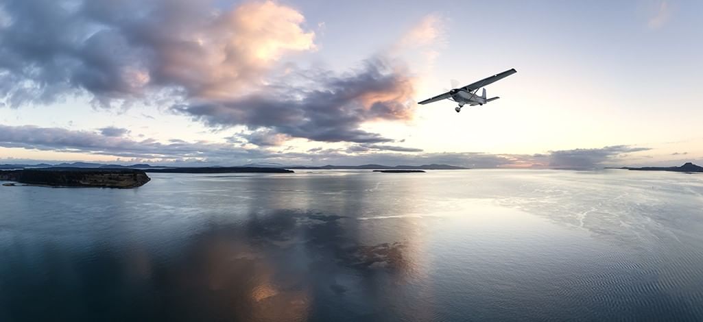 a scenic seaplane over coastal waters at sunset