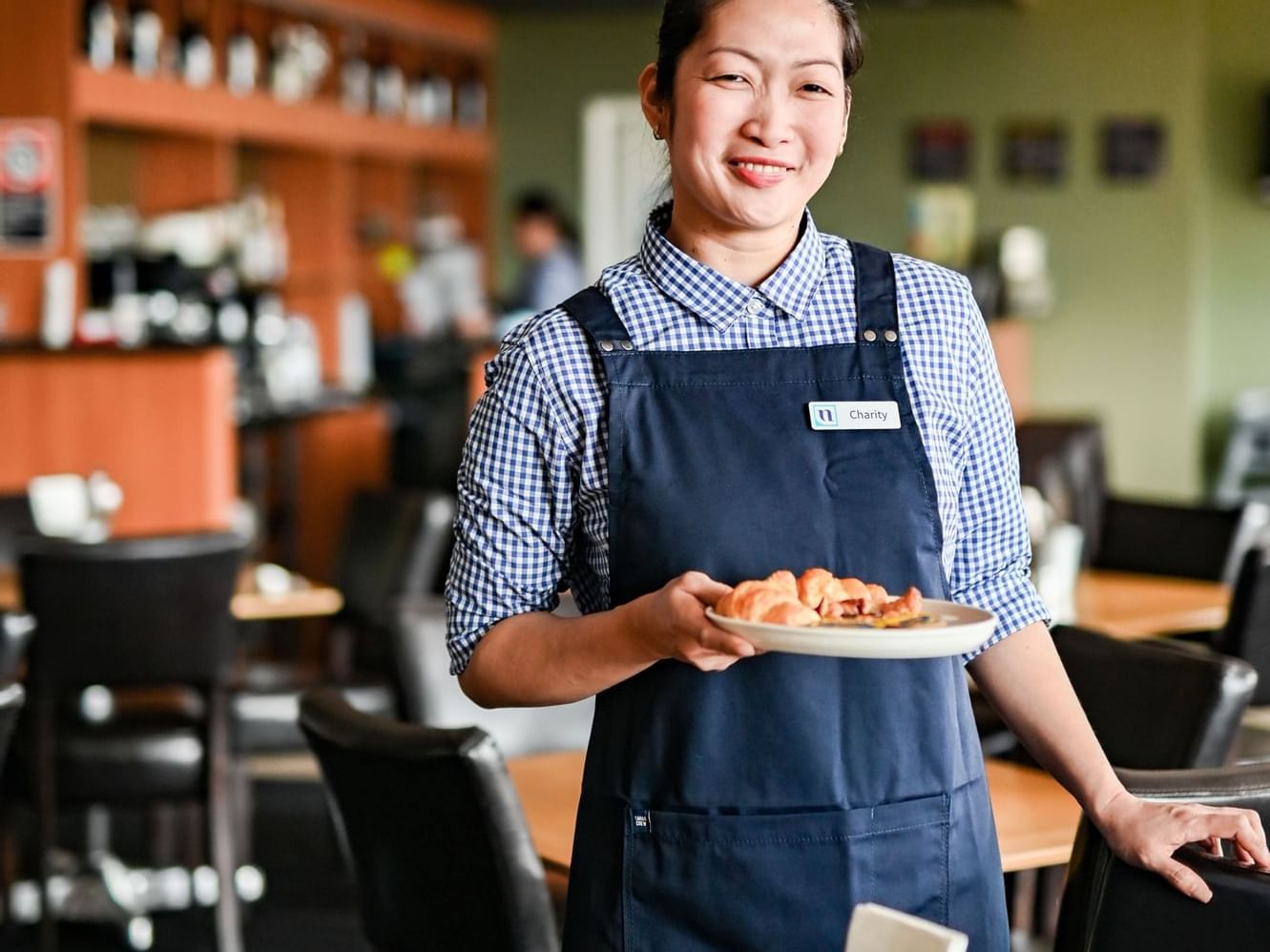 Waitress with a plate of food at Nesuto Parramatta Apartment Hotel