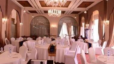 Elegant banquet hall with round tables and white linens for high-end conferences in africa at Serena Hotels & Resorts