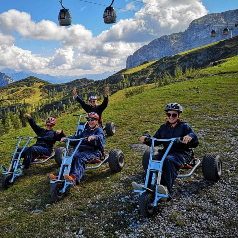 4 friends on mountain carting near Falkensteiner Hotels
