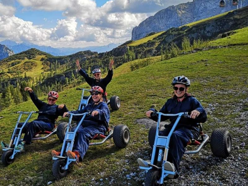 4 friends on mountain carting near Falkensteiner Hotels