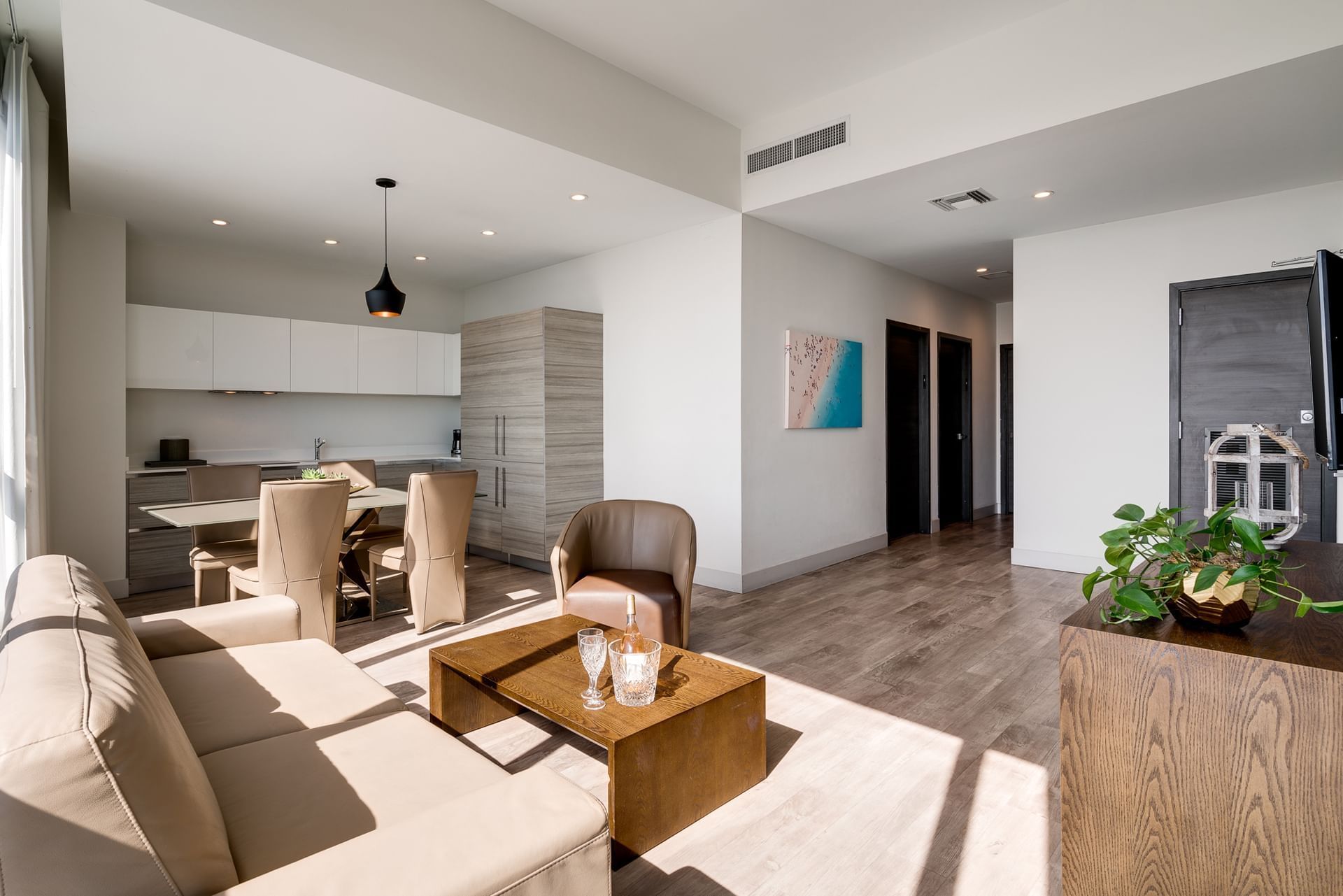 A modern living room with a kitchenette and dining area.