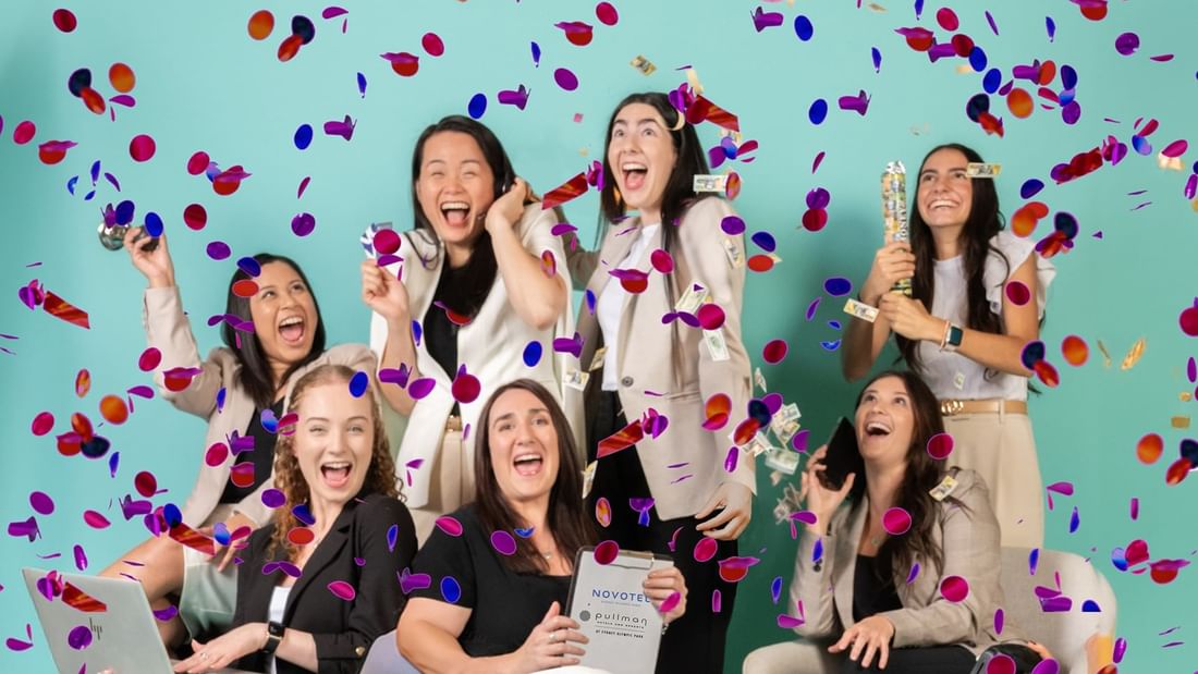 Joyful ladies celebrating with confetti in the air and holding party poppers at Novotel Sydney Olympic Park