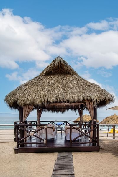 Palapa de techo de palma con barandillas de madera sobre la arena, con vistas al mar en el Zenset Spa del hotel Sunset Plaza Beach Resort, uno de los mejores hoteles con vistas a la playa en Puerto Vallarta
