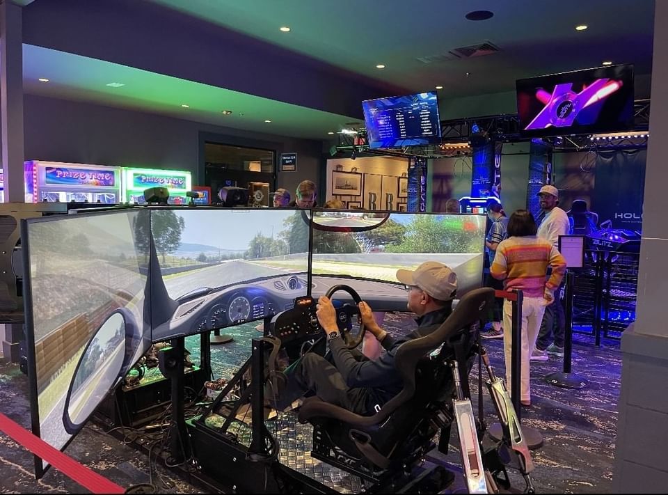 Man playing a car simulator in the Indoor Bar Games at Shangri-La Monkey Island