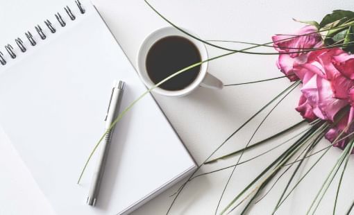 Coffee and flowers with a notepad on a table at Sunway Hotel Seberang Jaya