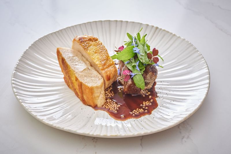 Garnished meat dish served on a white plate in Le West Restaurant at Hôtel Westminster - Paris
