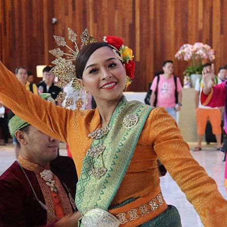 Lady dancing happily while wearing traditional clothes in Lexis MY