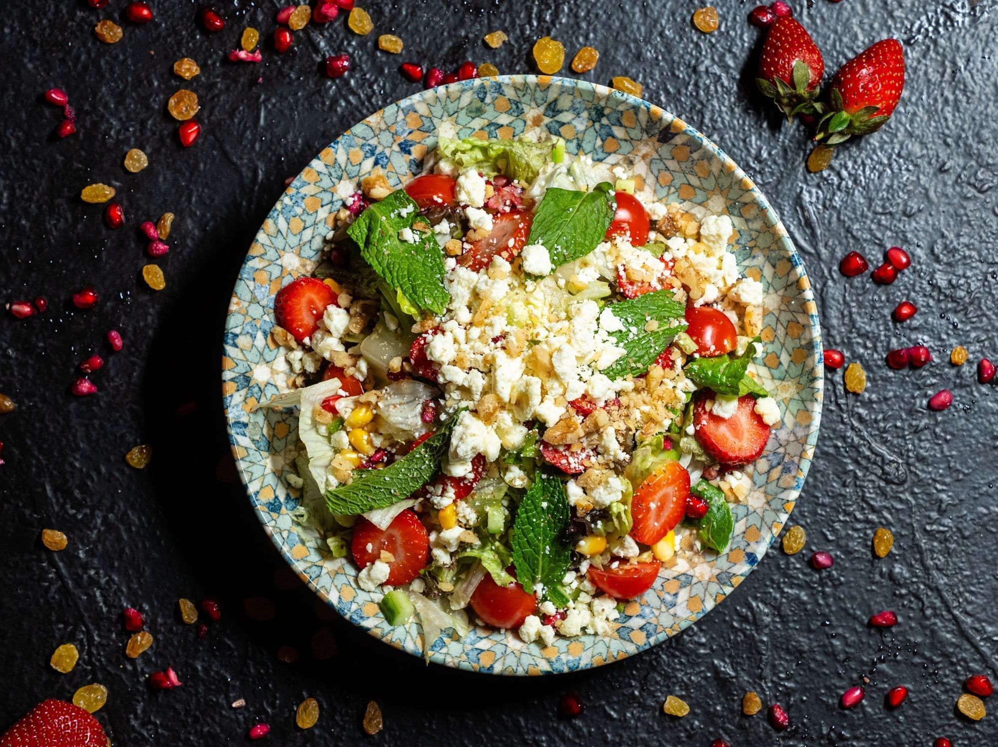 Fresh salad with feta cheese, strawberries, and pomegranate dish served in Restaurant and Lounge at DAMAC Maison Aykon City