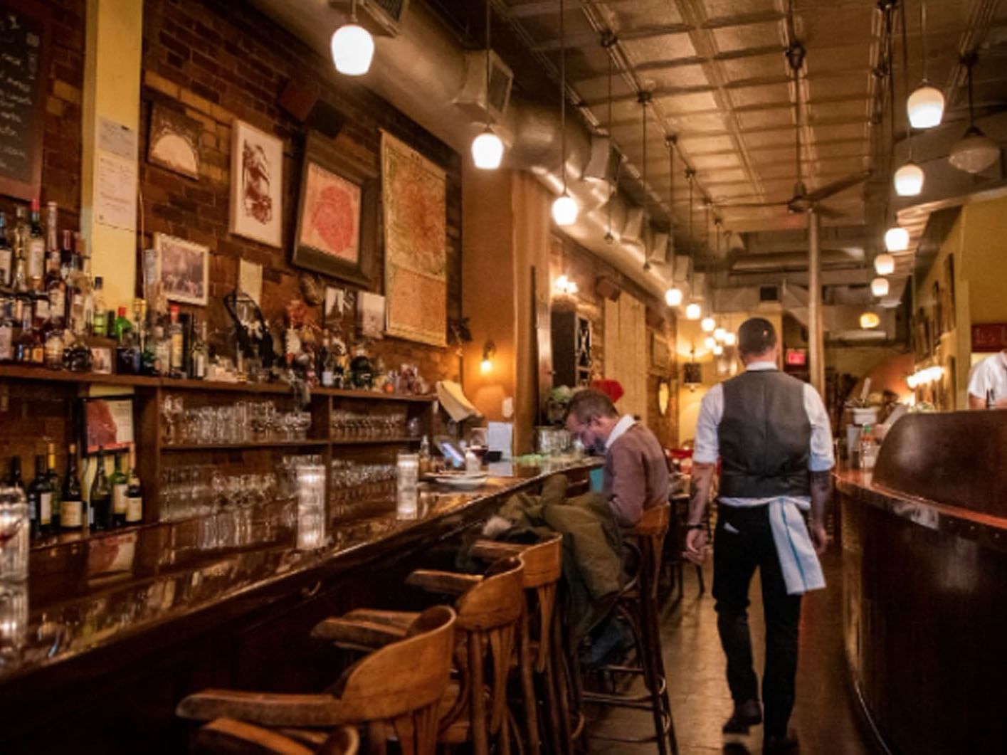 La Palette with patrons and bartender, warm lighting, and brick walls near Hotel X Toronto