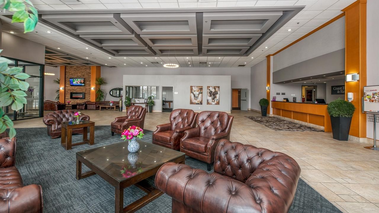 Lobby with couches, coffee tables, and reception desk at Coast Lethbridge Hotel & Conference Centre.