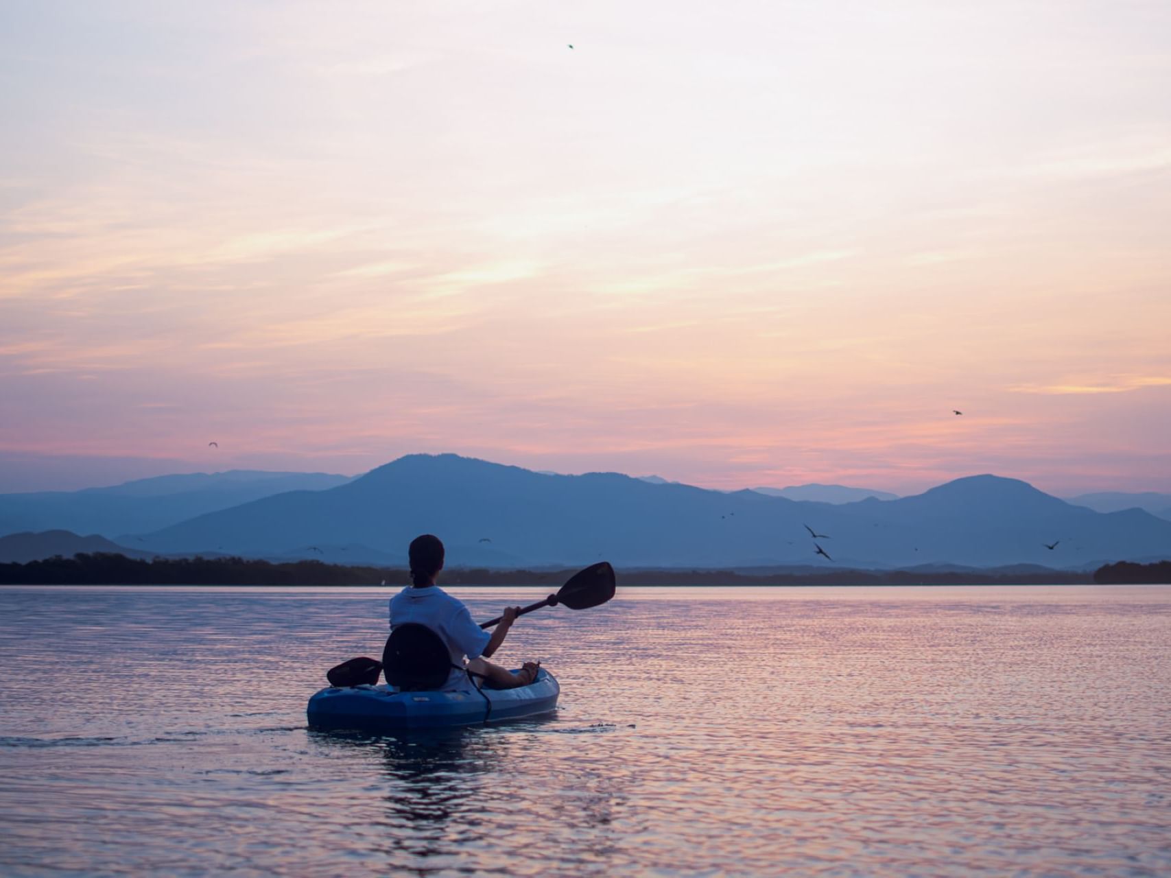 A man kayaking on river near Marea Beachfront Villas