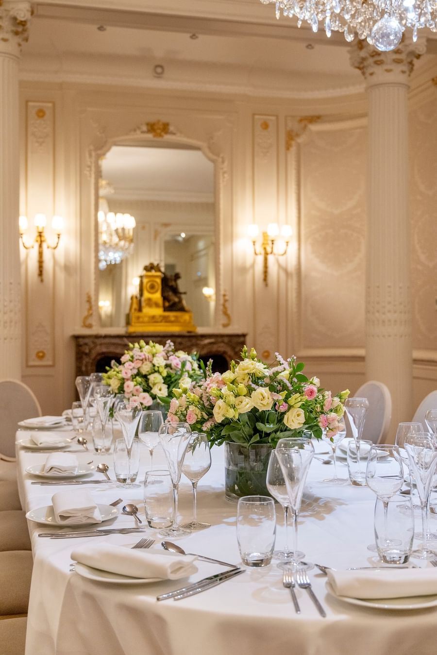 Table élégante avec bouquets de fleurs roses et blanches dans une salle à manger classique à l'Hotel Westminster Warwick Paris