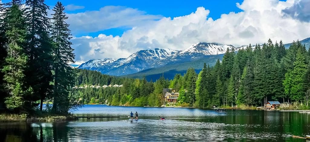 View of Alpha Lake in Whistler with snowy mountains in the background