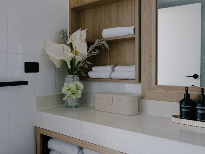 Sunset Junior Suite – Elysium Floor at Elysium Noosa vanity with lilies by neat towels nearby, best places to stay in Manly