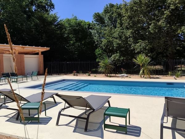 Outdoor pool area with sun loungers surrounded by lush greenery at the Saint James Hotel