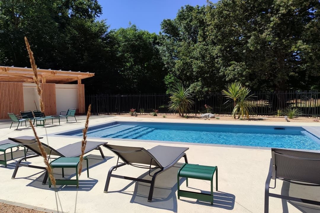 Outdoor pool area with sun loungers surrounded by lush greenery at the Saint James Hotel