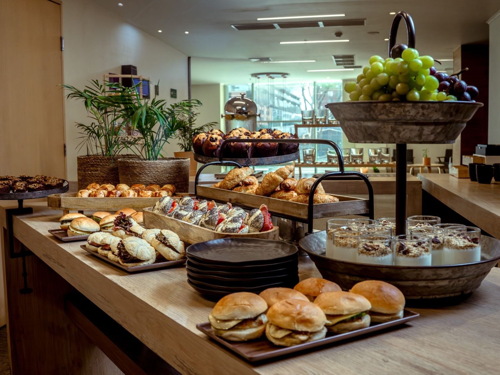 Mesa de bufé con diversos pasteles, bocadillos y fruta en el hotel HCC Costanera Concepción.