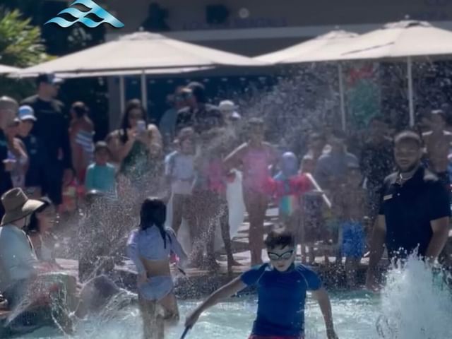 Personas reunidas y disfrutando de actividades en la piscina, como parte de los Juegos Acuáticos en Las Casitas Village.