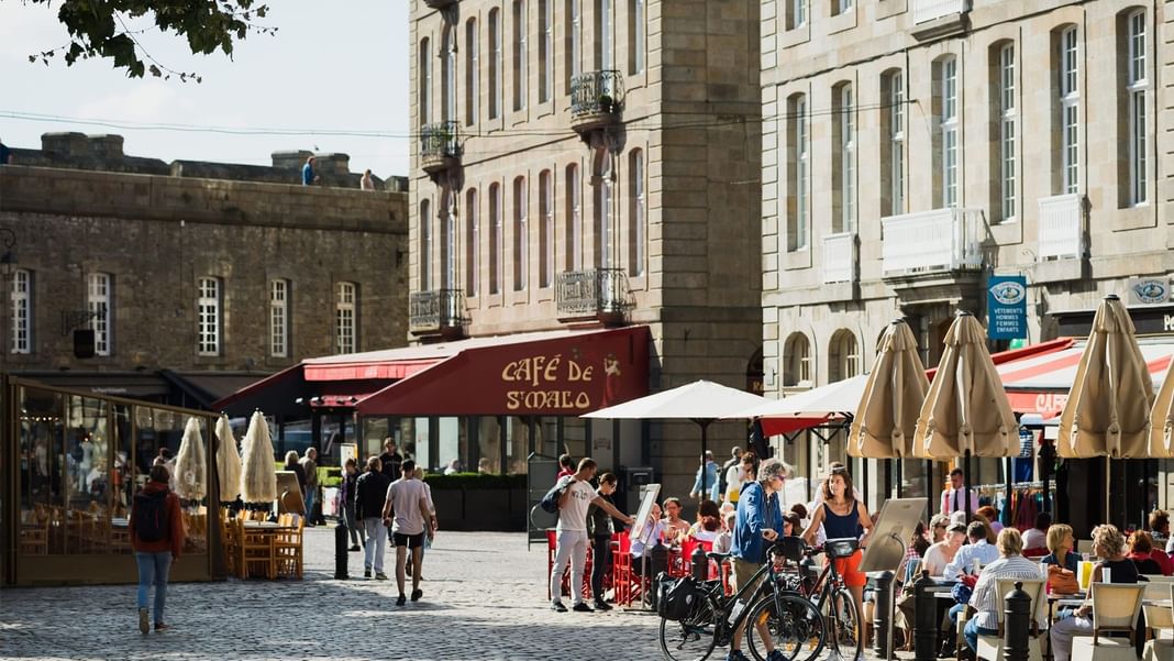 Marché de rue animé avec des gens rassemblés à l'extérieur près des Hôtels Oceania