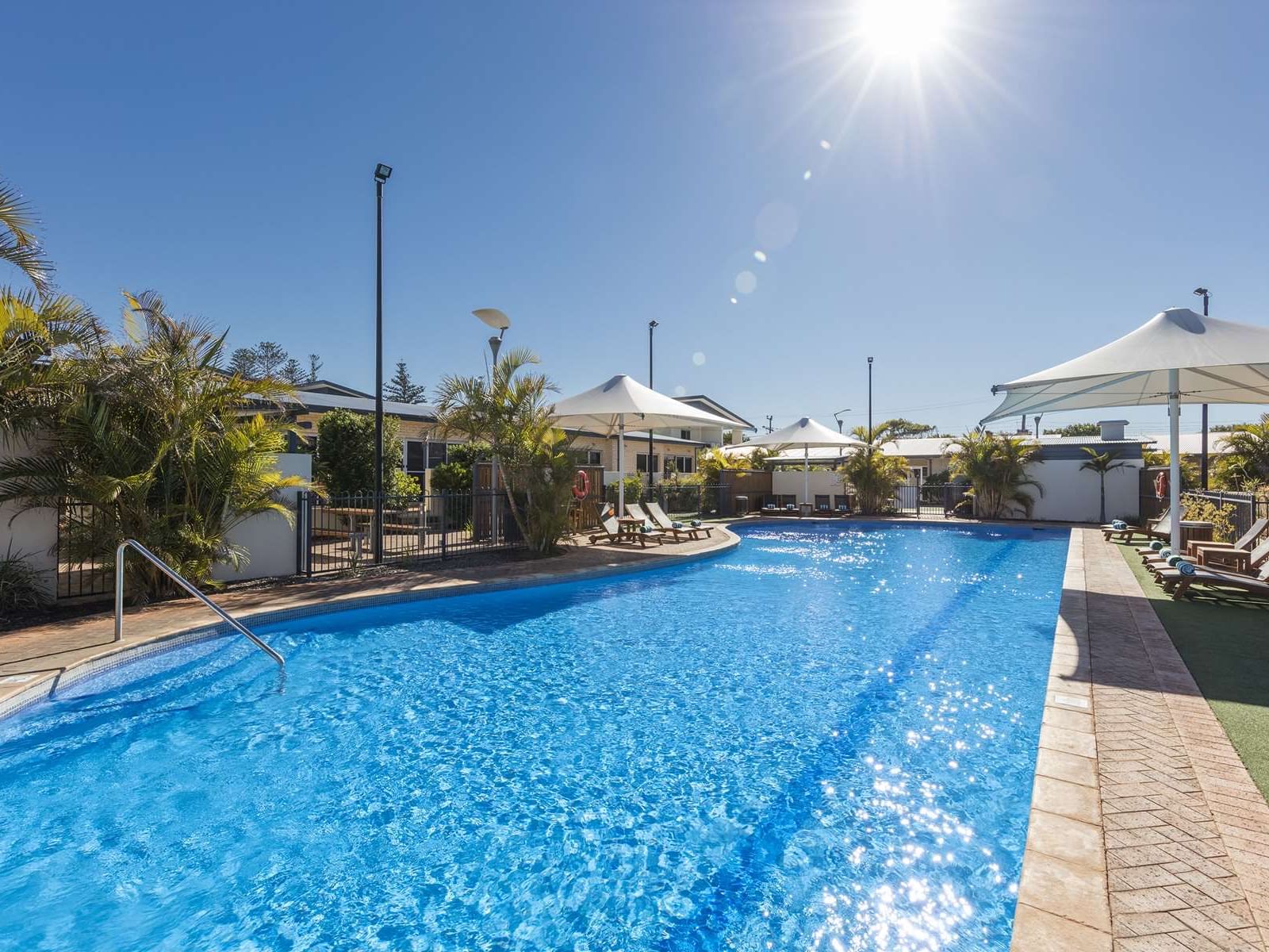 Sunbeds by the outdoor swimming pool area at Nesuto Hotels