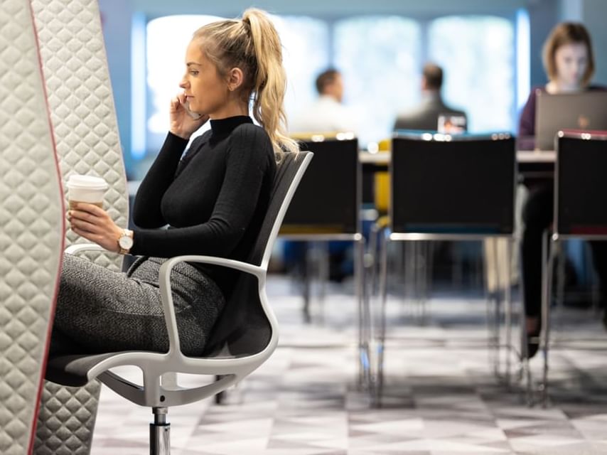 A lady using the mobile while working at Village Hotel Cardiff