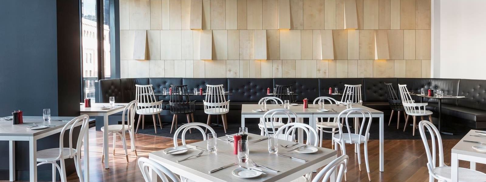 Ibis Kitchen Restaurant dining area featuring modern white and black seating at Ibis Adelaide