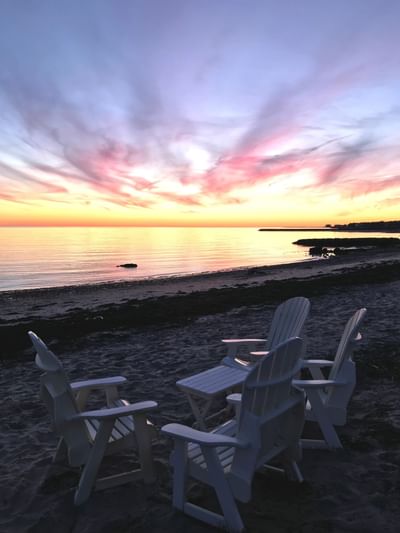 Outdoor chairs by the beach captured during sunset at Chatham Tides Resort