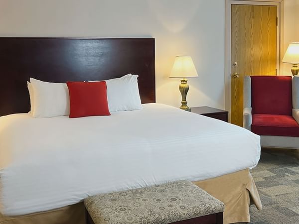 Premium King bedroom with bed, chair, air conditioning, lamp, and nightstands