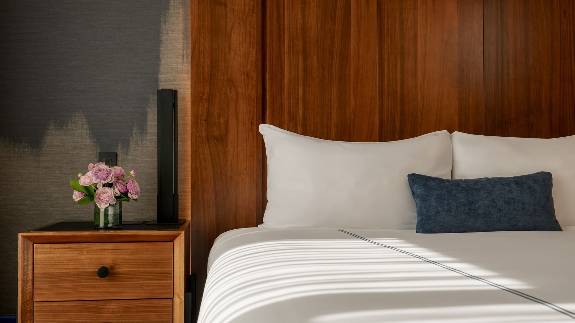 Terrace Room with a plush bed, nightstand, and flowers at Gansevoort Meatpacking, one of the great hotel rooms in Manhattan