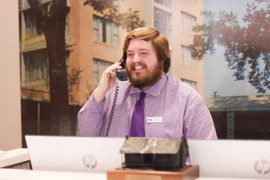 a man smiles as he answers a phone