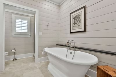 Deluxe King Cottage bathroom with bathtub, wood accents, and wall art by Cottages at Laurel Brooke
