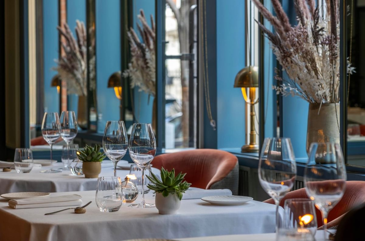 Dining tables set, by mirrors, under dried bouquets in the restaurant at The Capital Hotel, Apartments and Townhouse