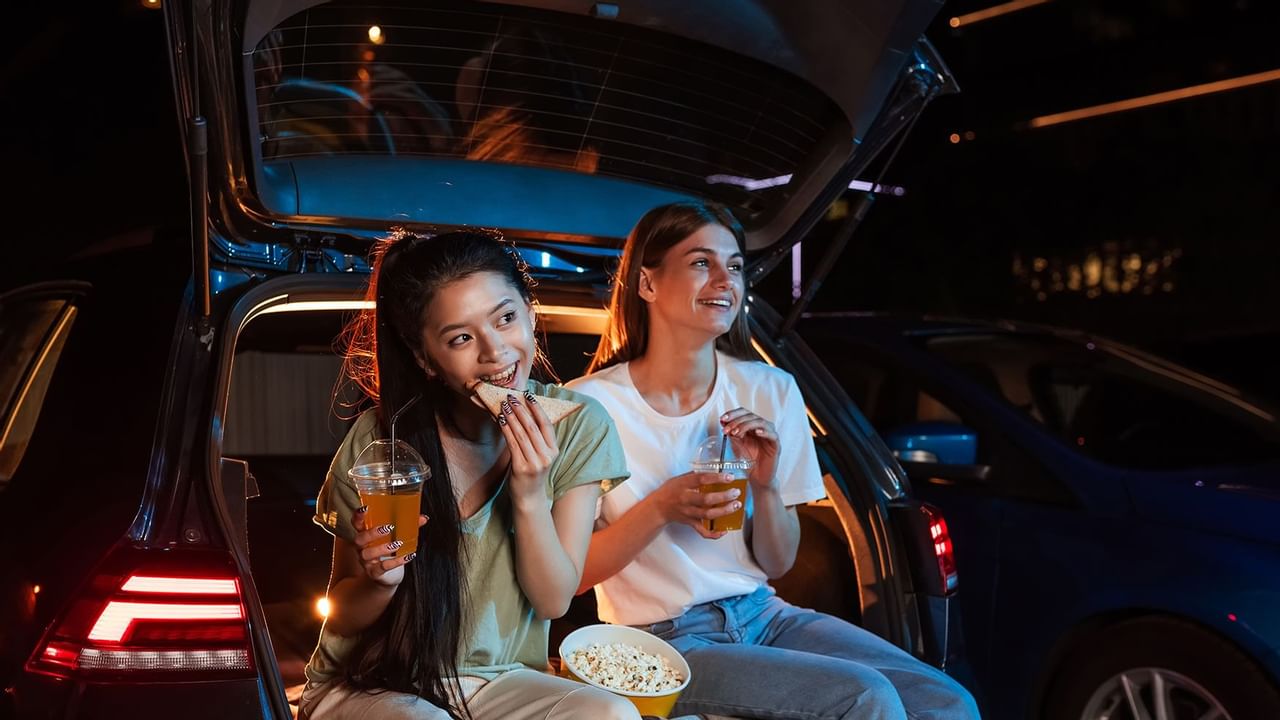 kids sitting in truck of a car enjoying snacks