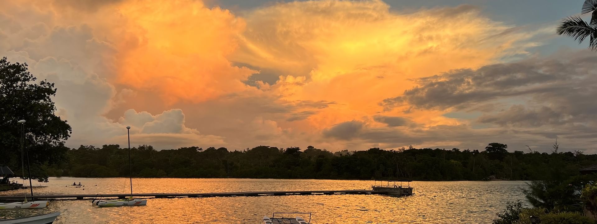Sunset view over a serene lake with boats at Warwick Le Lagon - Vanuatu in Efate