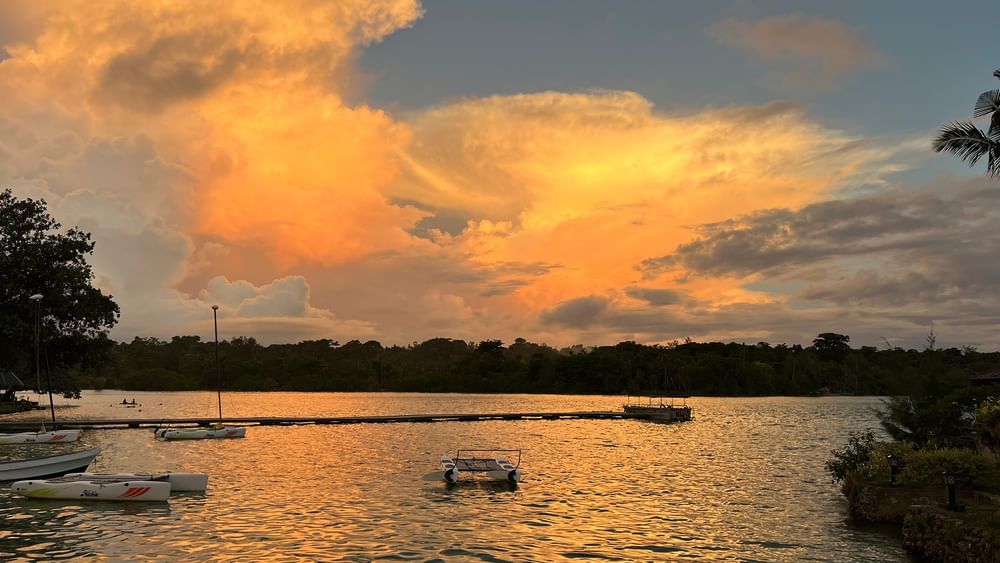Sunset view over a serene lake with boats at Warwick Le Lagon - Vanuatu in Efate.