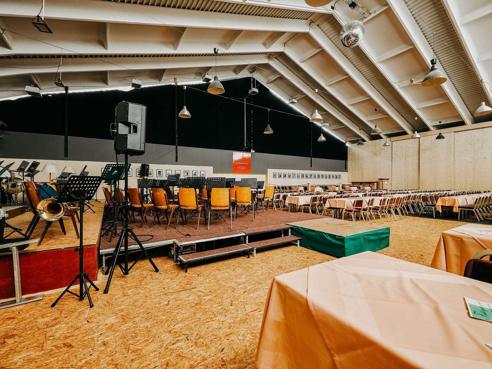 Eventhalle mit Bühne, Tafeln und Ausstattung.