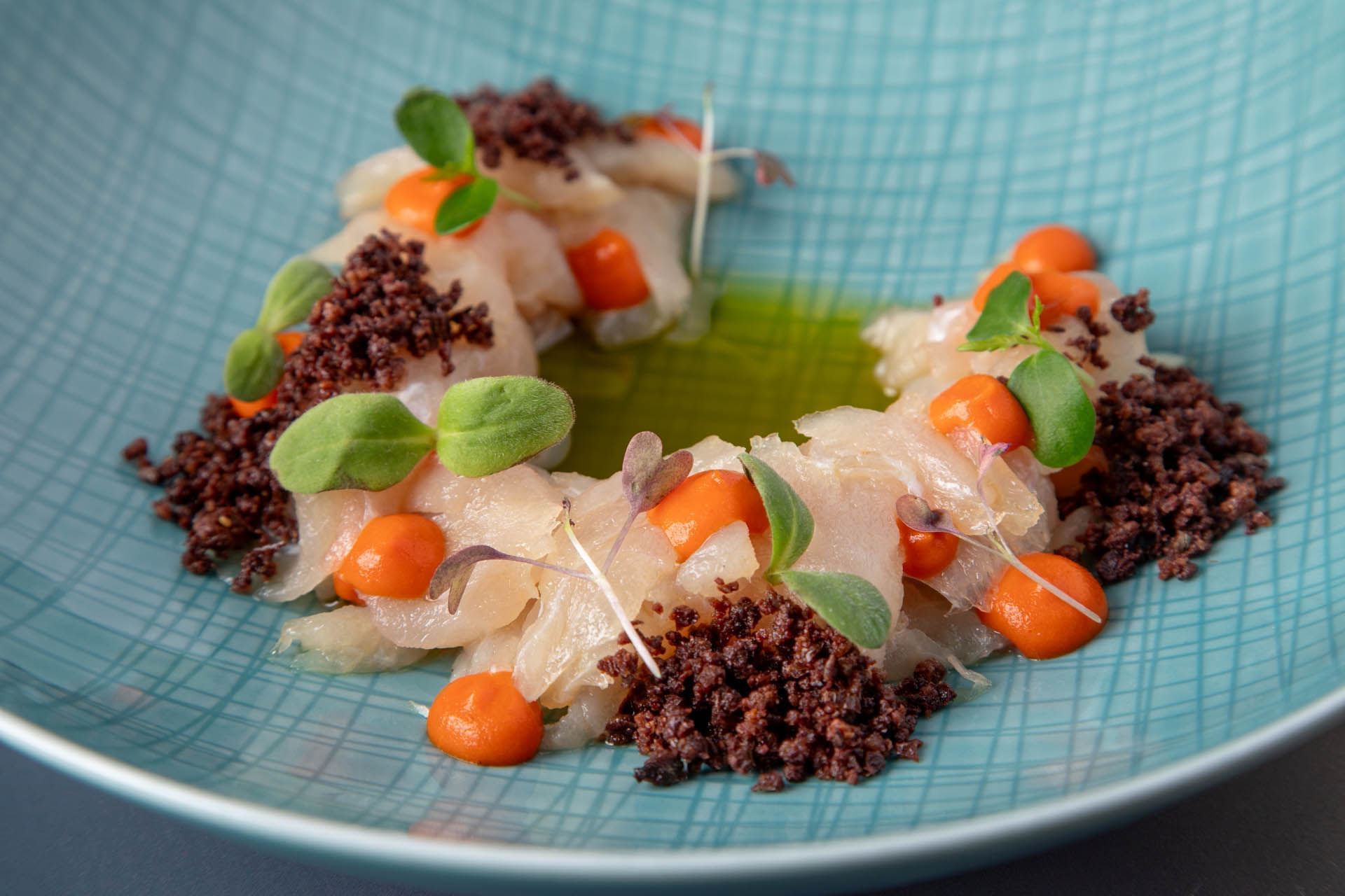 Close-up of Fluke Crudo plate served at The Glam Hotel