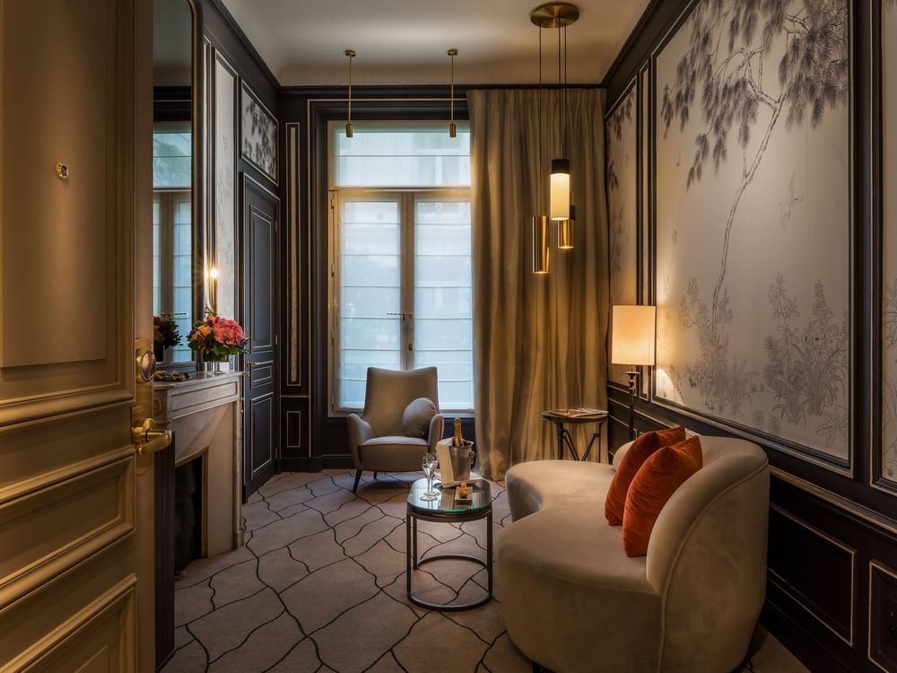 TV lounge with plush sofa by the window in Deluxe Parisienne Suite at Hotel Westminster Paris