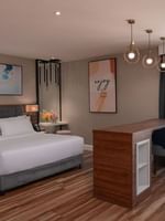 King bed by a tall wooden bar table and two chairs in Deluxe Room City View at Warwick Al Jubail
