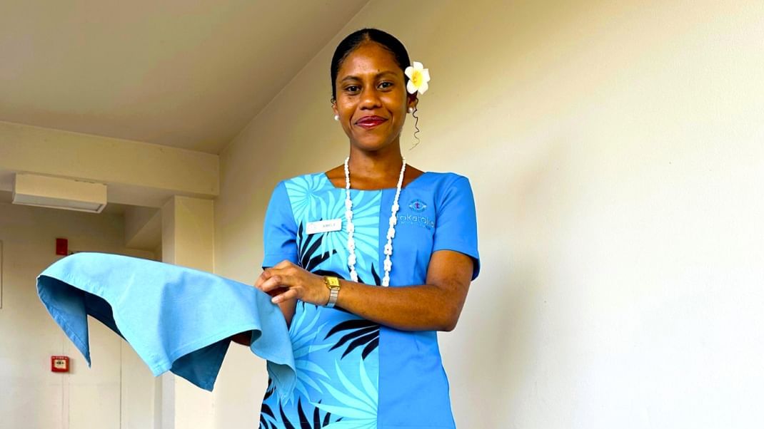 Staff member in a blue floral shirt holding a cloth near a white wall at TokaToka Resort Nadi Fiji