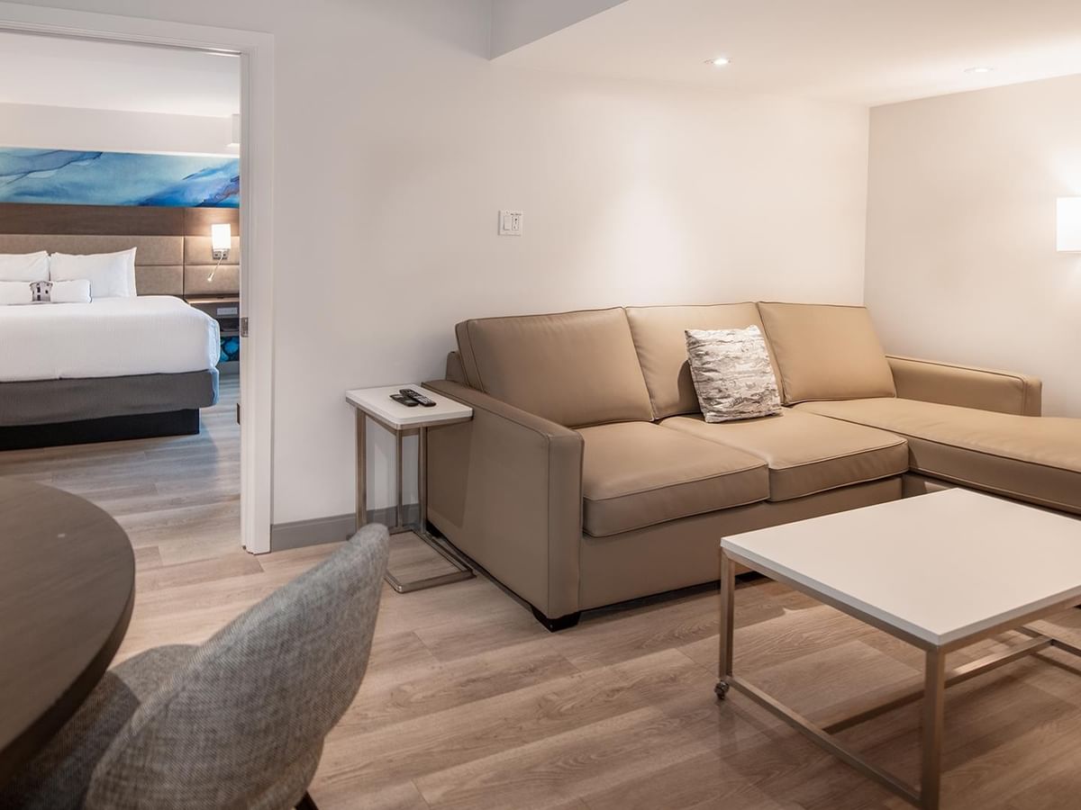 Living room with couch and table in Coast Premium King One Bedroom Suite at Coast Bastion Hotel in Nanaimo.