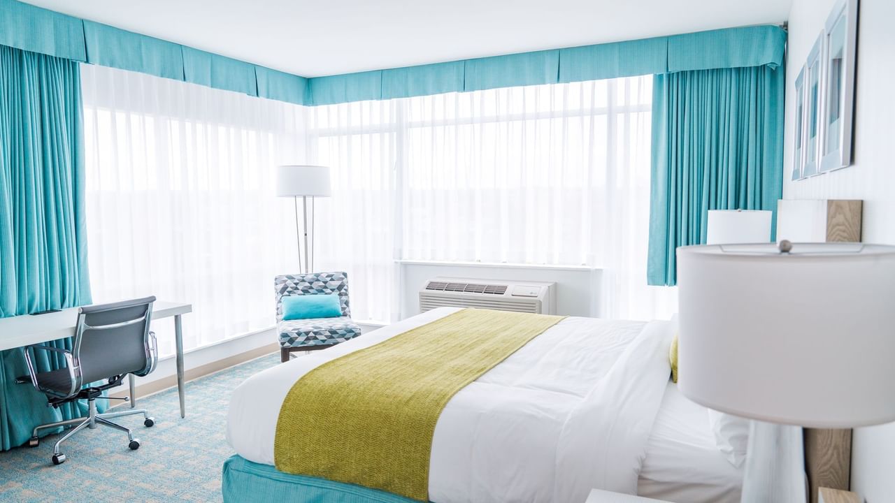 Bed in hotel room with green and blue colors