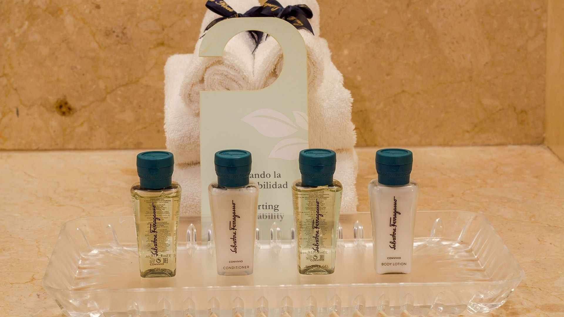 Salvatore Ferragamo hotel toiletries on a tray in front of rolled towels in Double Grand Class Suite at Quinta Real Puebla