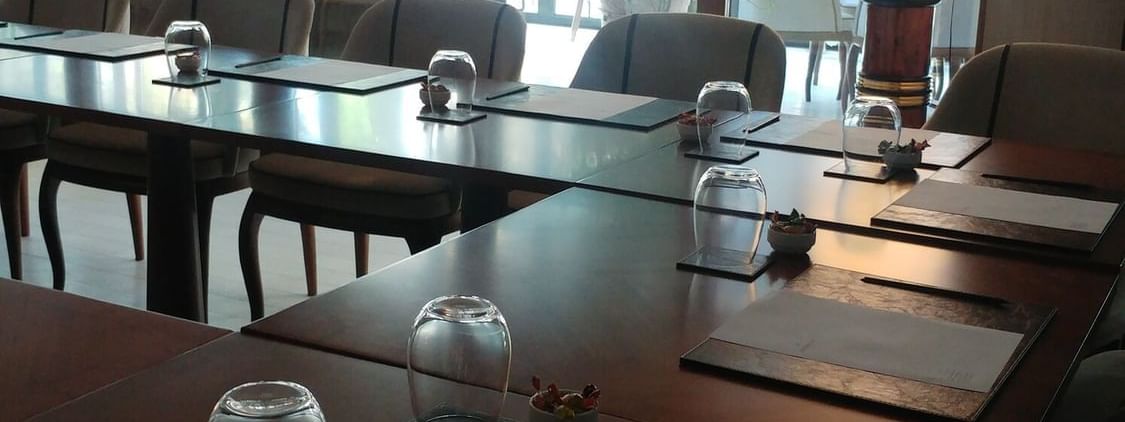Kugu 2 Hall features Water glasses by paper pads surrounding a wooden table at Warwick Ankara