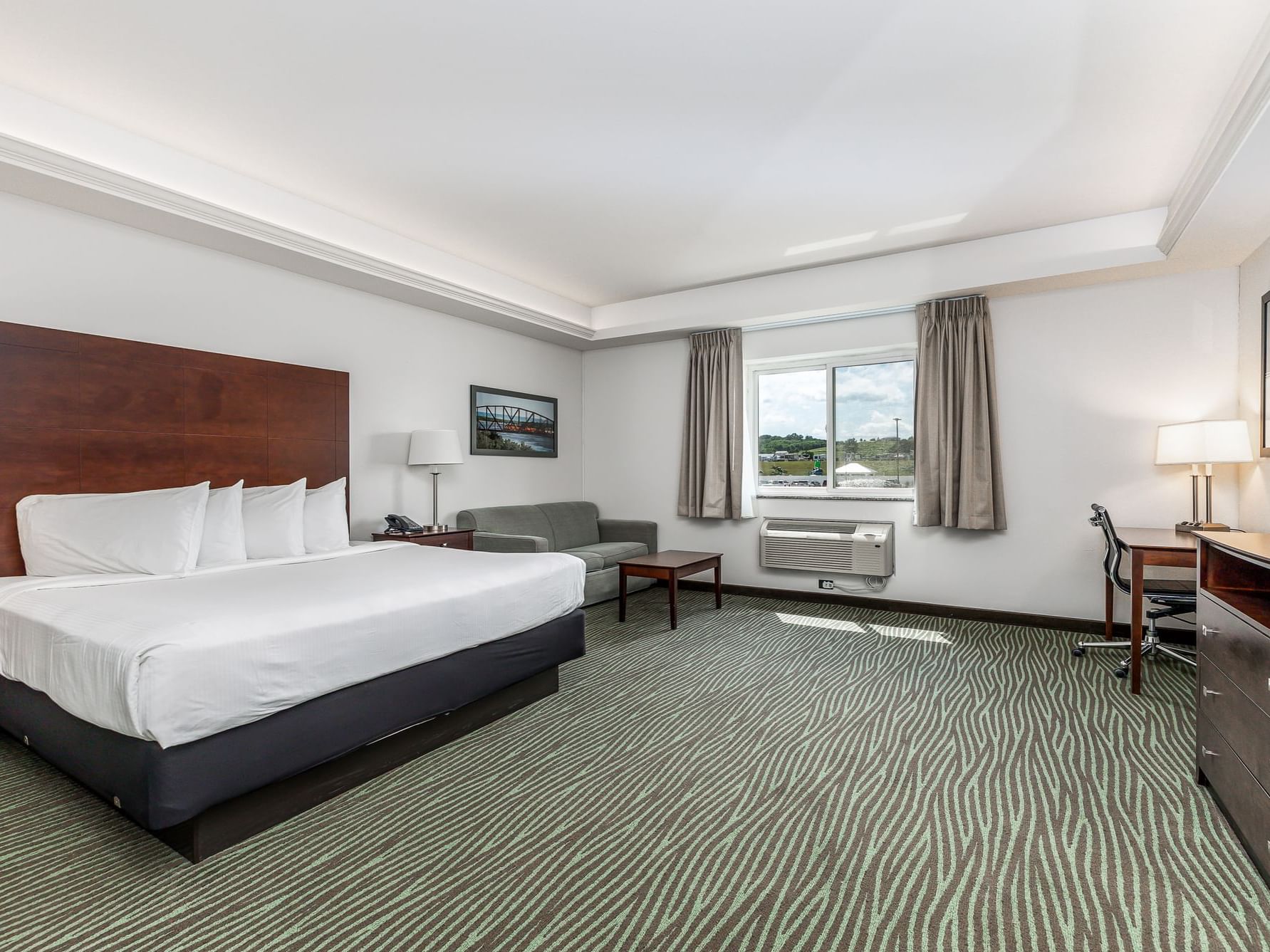 Seating area and work desk by the cozy bed with a sunlit window in the Business King Resort View at Off Shore Resort